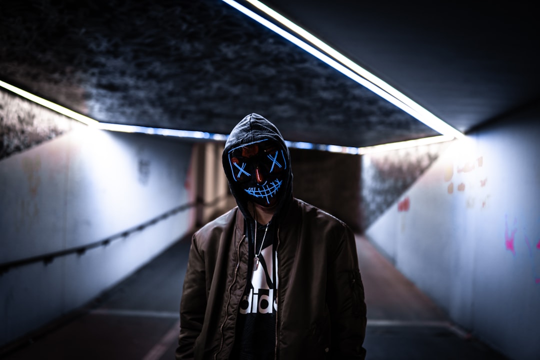 a person wearing a neon mask in a dark room